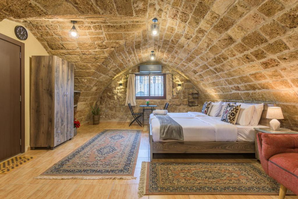 a bedroom with a large bed in a stone wall at Timberwood Studio in Batroun in Batroûn