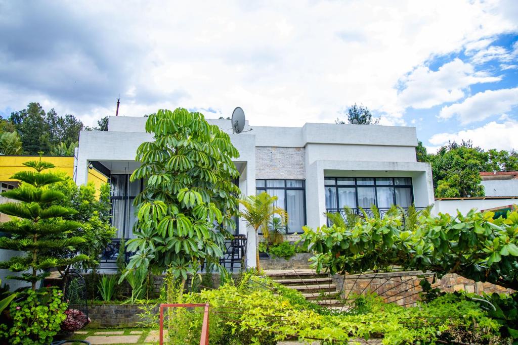 ein weißes Haus mit einem Bananenbaum davor in der Unterkunft Casablanca in Kigali in Kigali