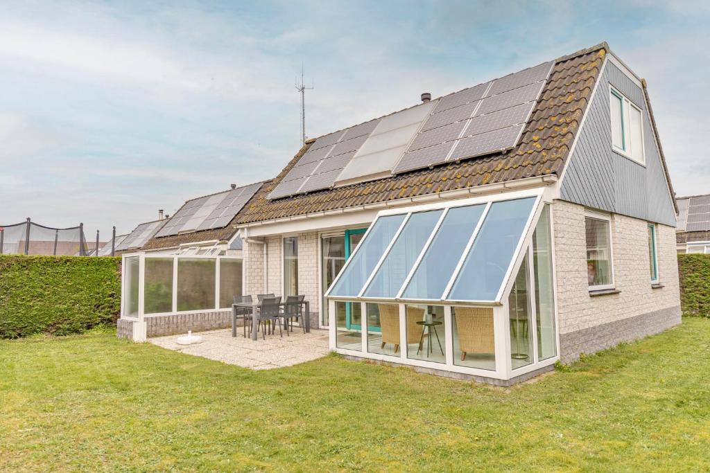 une maison avec des panneaux solaires sur le toit dans l'établissement Bohemien Resort 8, à Sint Maartensvlotbrug