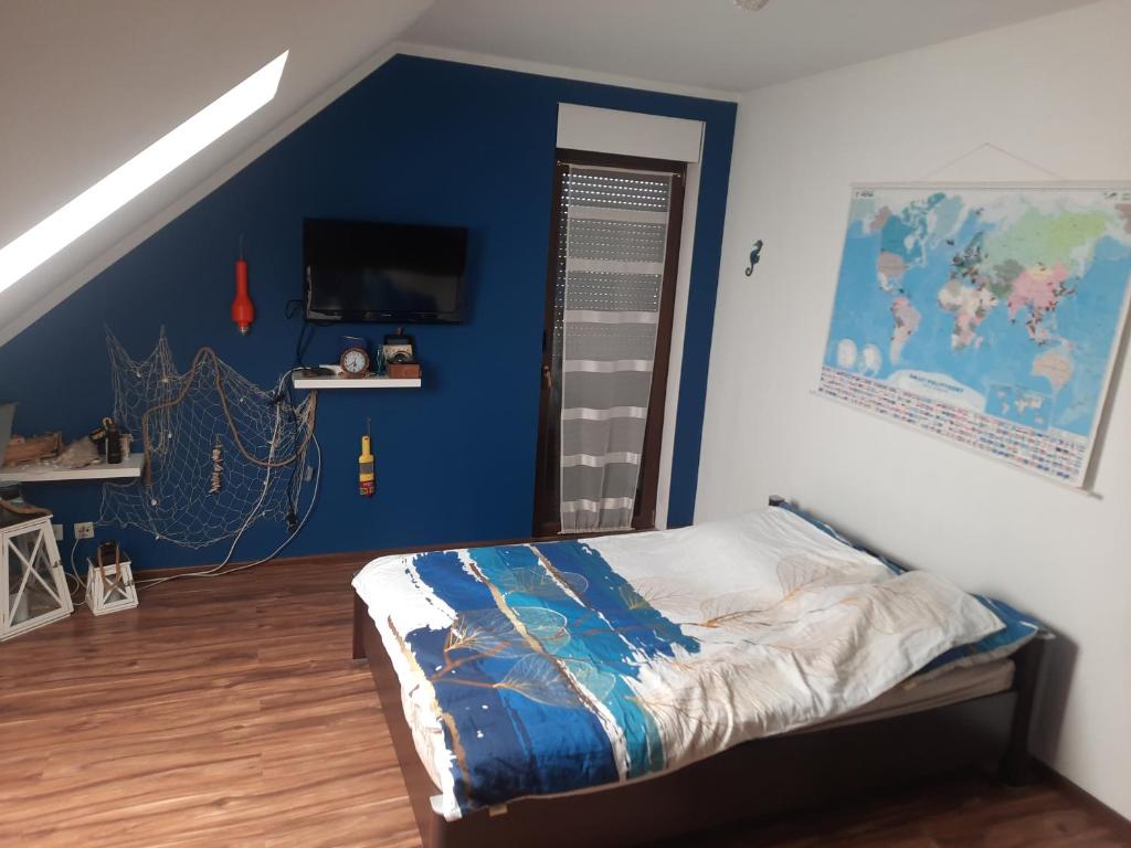 Schlafzimmer mit einem Bett mit blauer Wand in der Unterkunft NOCLEGI u ANI in Otmuchów