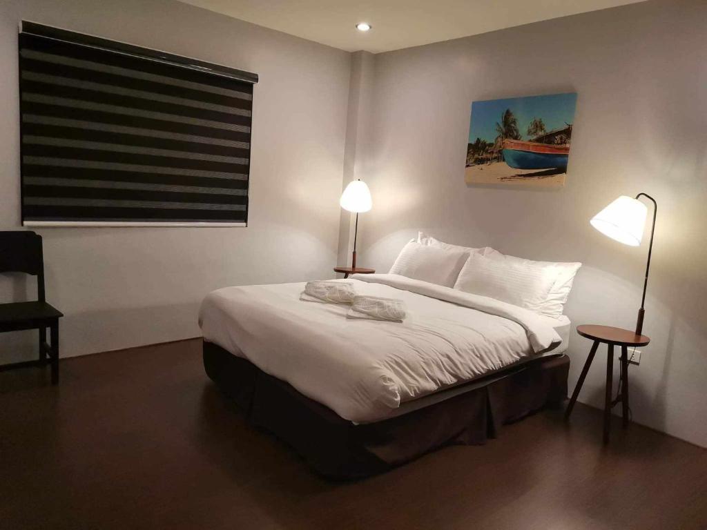 1 dormitorio con 1 cama con 2 lámparas y una ventana en Kopinos Tourits Inn en Del Carmen