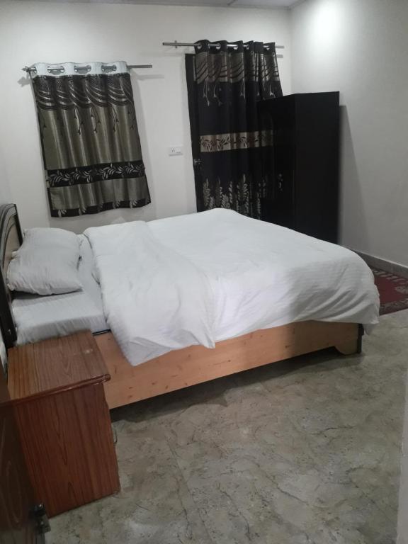 1 dormitorio con 1 cama con marco de madera en 0 point home stay Mussoorie, en Mussoorie