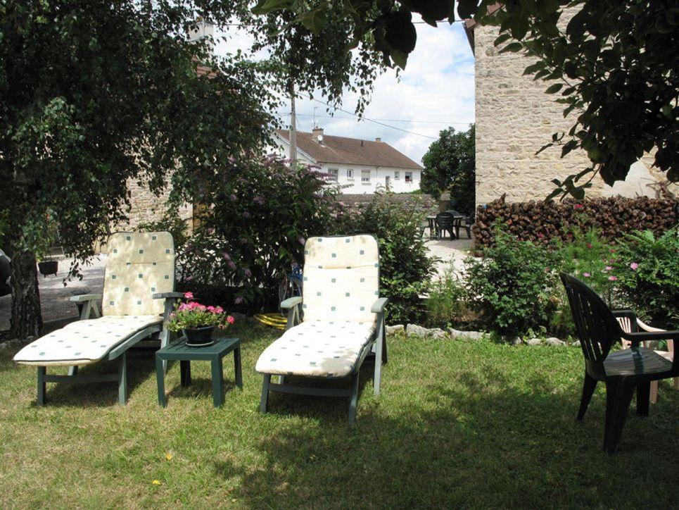 three chairs and a table in the grass at Le Caméléon in Corgoloin
