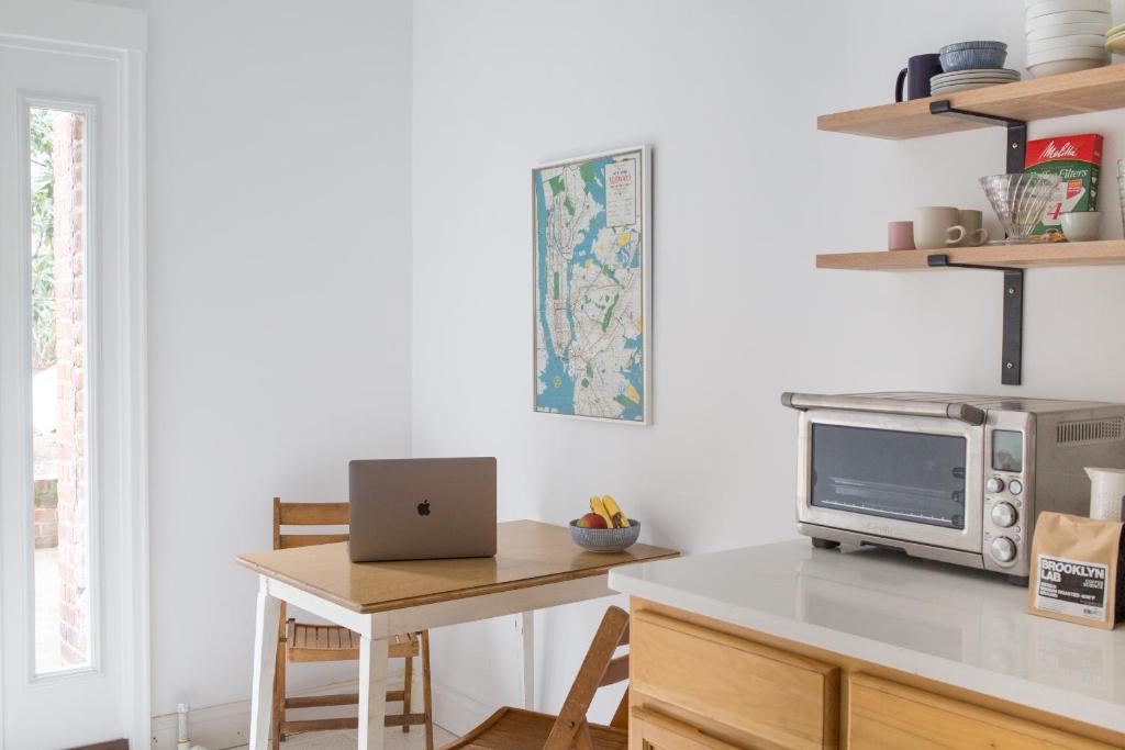 a kitchen with a table with a laptop on it at Garden Guest Suite in Brooklyn
