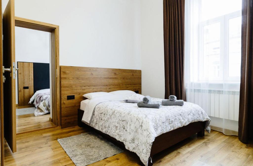 una camera con un letto e un grande specchio di Опал a Stryj