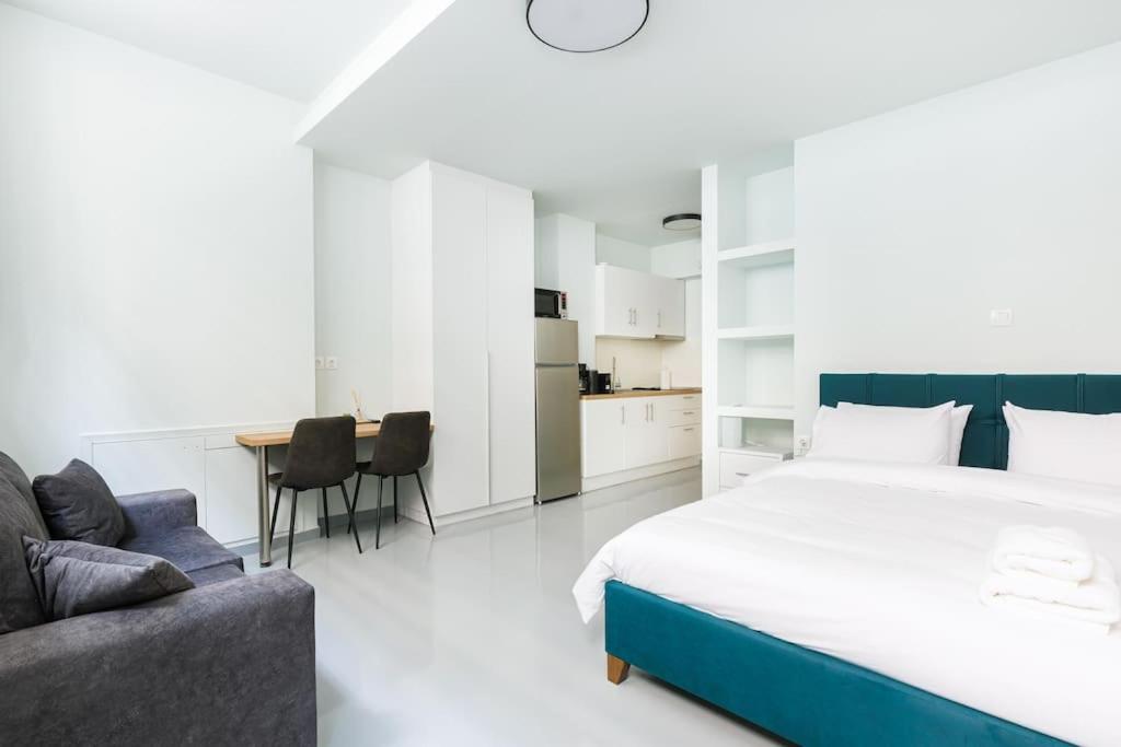 ein Schlafzimmer mit einem großen Bett, einem Tisch und Stühlen in der Unterkunft Snug studio apartment with shared garden II in Athen