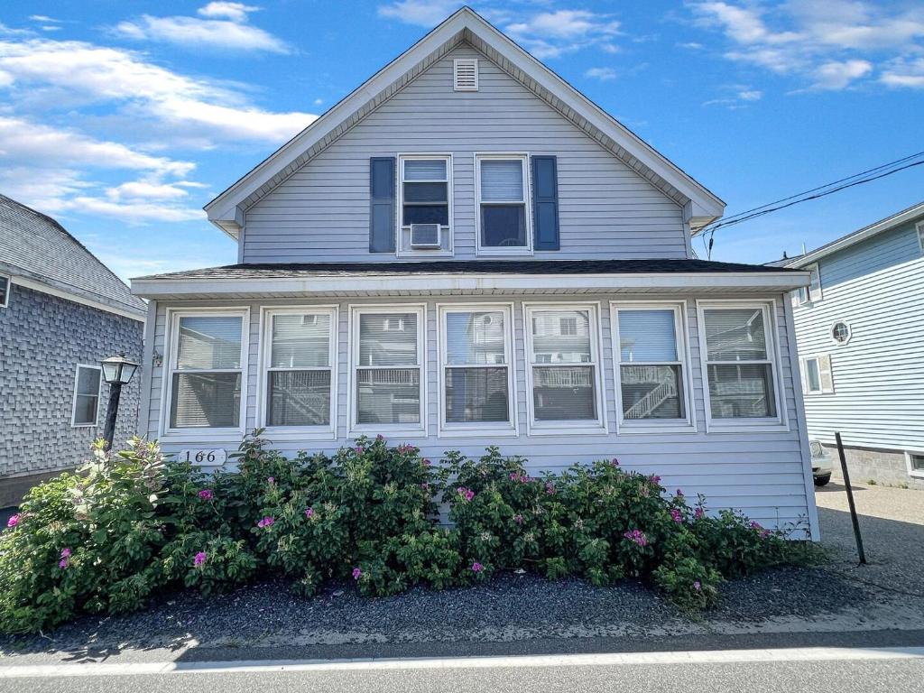 a white house with some flowers in front of it at Sweet Dreams W032 Brought to you by GetAway Vacations in Wells