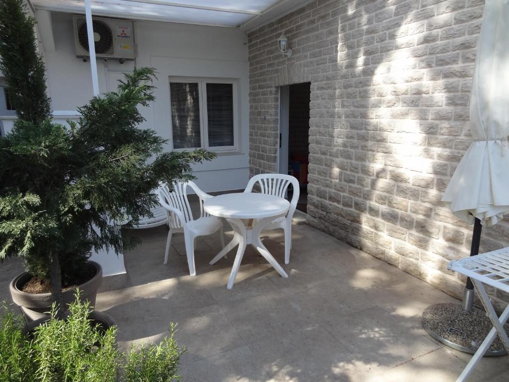 a patio with two white chairs and a table at Apartment Rosabela in Primošten