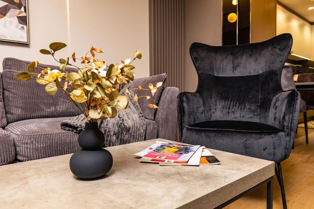 uma sala de estar com uma mesa com um vaso e uma cadeira em Central Victoria Home 2-bedroom apt em Plovdiv