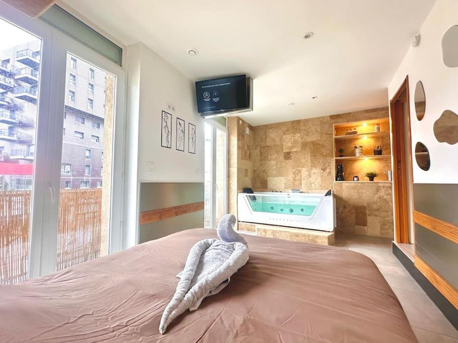 a room with a bed with a bath tub in it at Le Spa Dijonnais in Dijon