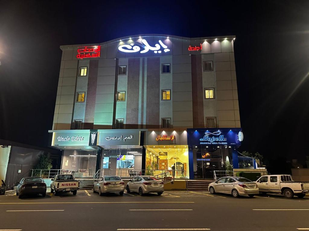 a building with cars parked in a parking lot at night at اجنحه ايلاف الفندقية in Abha