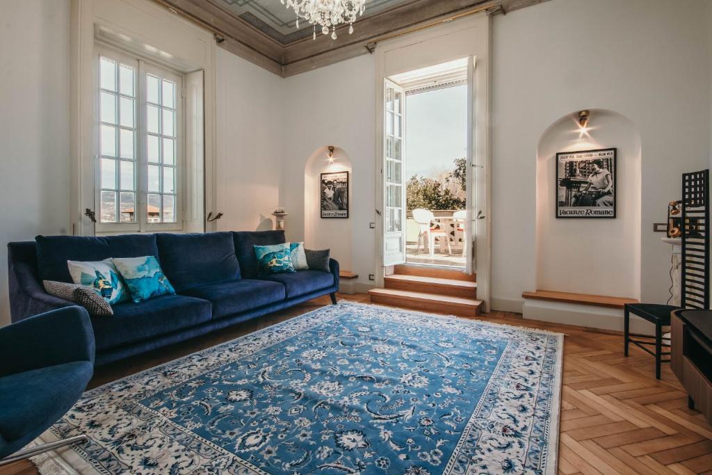 een woonkamer met een blauwe bank en een blauw tapijt bij The Queen's Suite - Villa Candela in Stresa