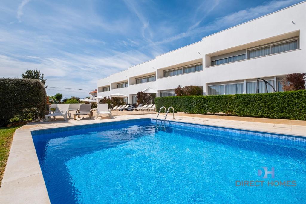 a swimming pool in front of a building at Villas Rocha in Albufeira