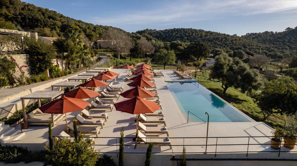 einen Blick über einen Pool mit Sonnenschirmen und Stühlen in der Unterkunft The Lodge Mallorca, Small Luxury Hotels in Sa Pobla