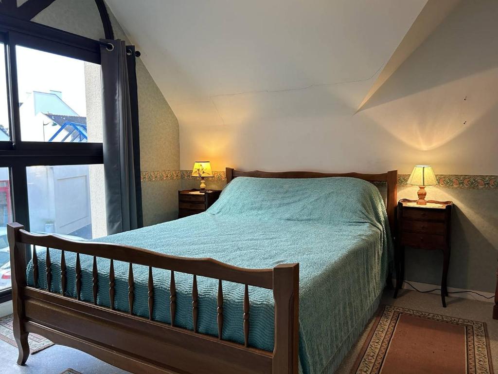 ein Schlafzimmer mit einem Bett und einem großen Fenster in der Unterkunft 539 - Maison 5 personnes en plein cœur d'Erquy. in Erquy