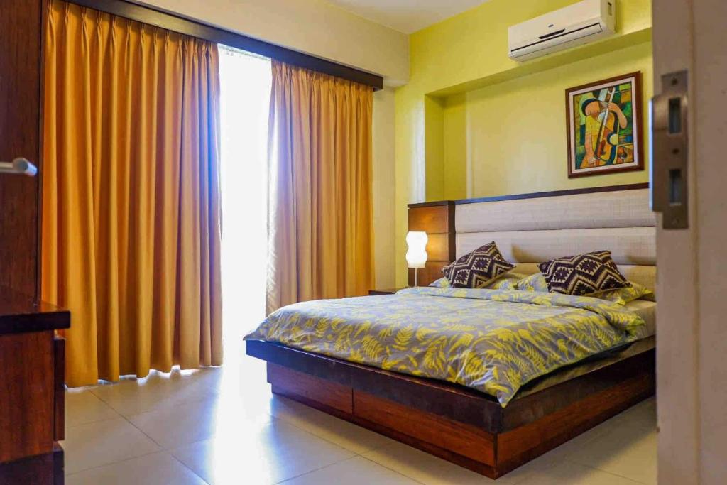 a bedroom with a bed and a large window at Miranda 514B 2br at Pico de Loro by Raquel's Place in Nasugbu