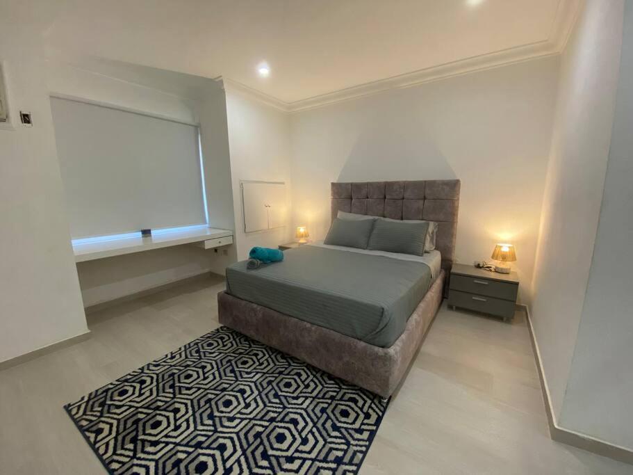 a bedroom with a large bed and a rug at Suite con acceso directo al Centro Comercial in Caracas