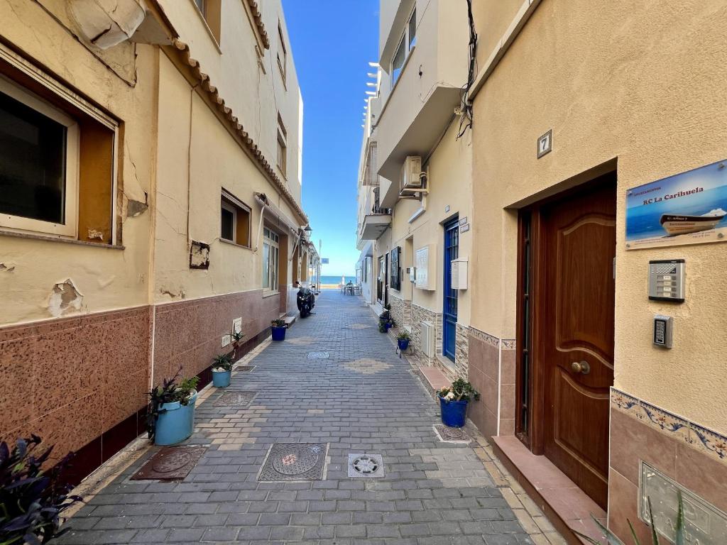 um beco entre dois edifícios com vasos de plantas em RC La Carihuela by Beehive Vacances em Torremolinos