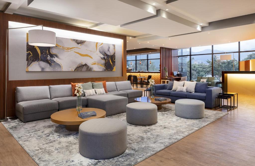 ボゴタにあるFairfield by Marriott Bogota Embajadaのソファとテーブルと椅子のあるリビングルーム