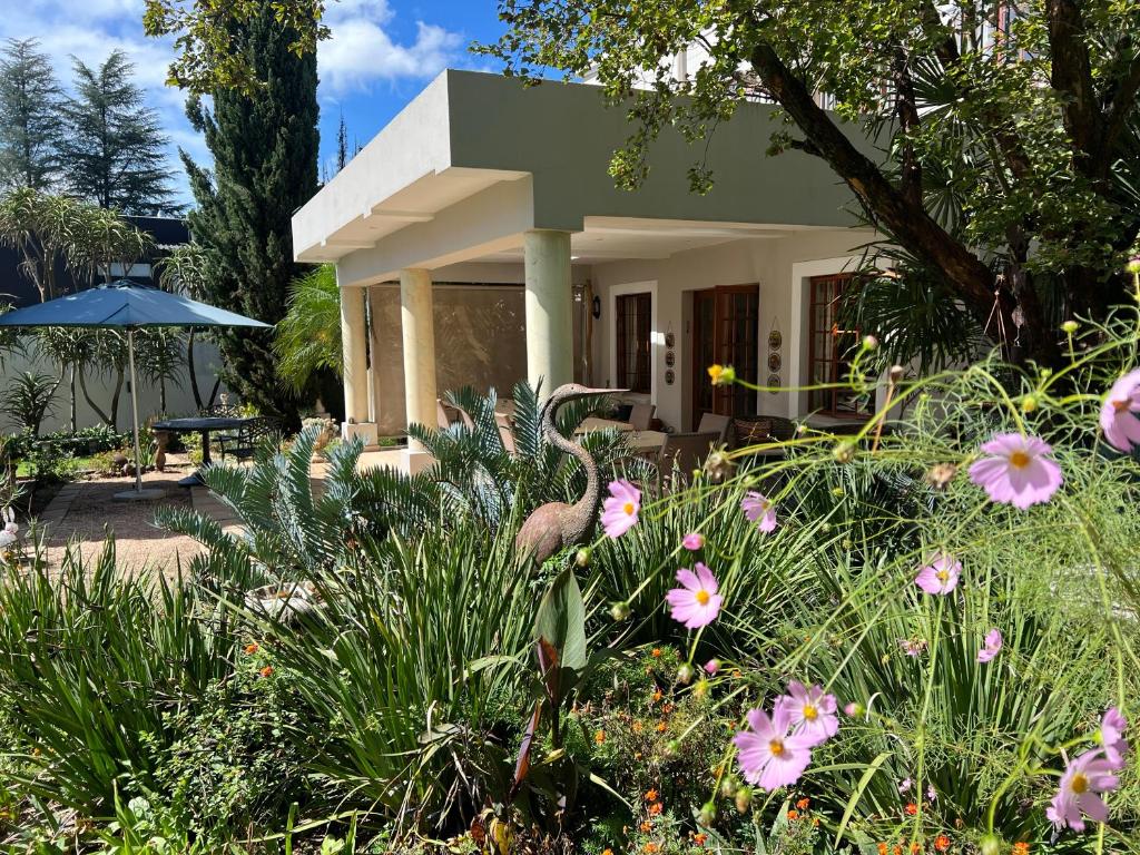 ein kleines Haus mit Blumen davor in der Unterkunft Highgrove Guesthouse in Johannesburg