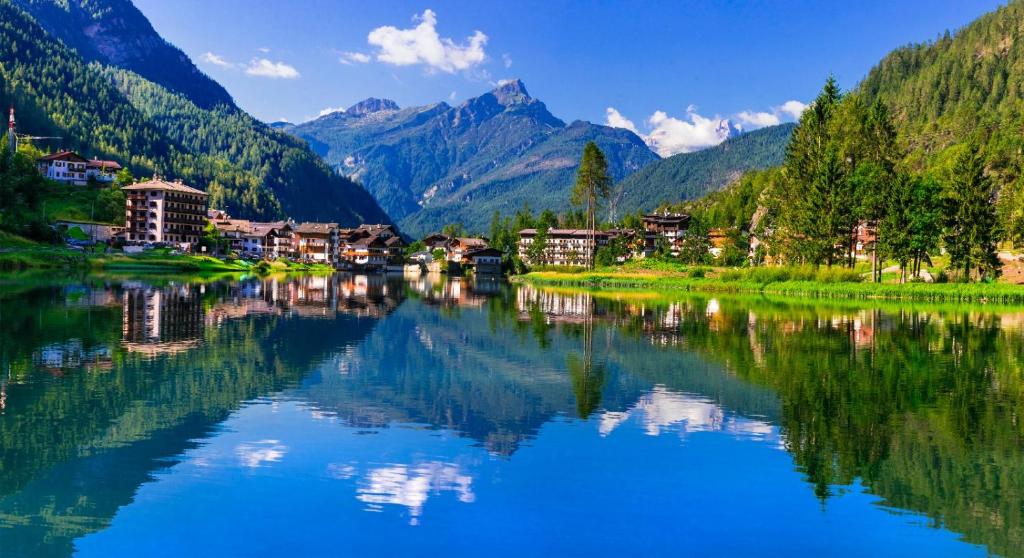 un pueblo en un río con montañas en el fondo en Ciasa de Carla en Masarè