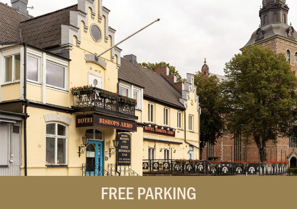 a building with a sign that reads free parking at Hotel Bishops Arms Kristianstad in Kristianstad