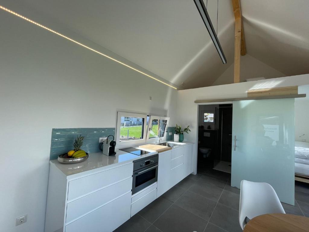 a kitchen with white cabinets and a sink at Tinyhaus Supreme für 4 Personen in Fuchsmühl