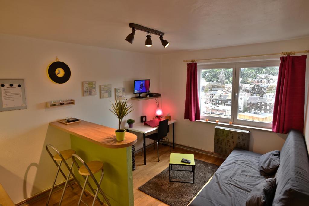 a living room with a couch and a table and a desk at Quai De Rome in Liège