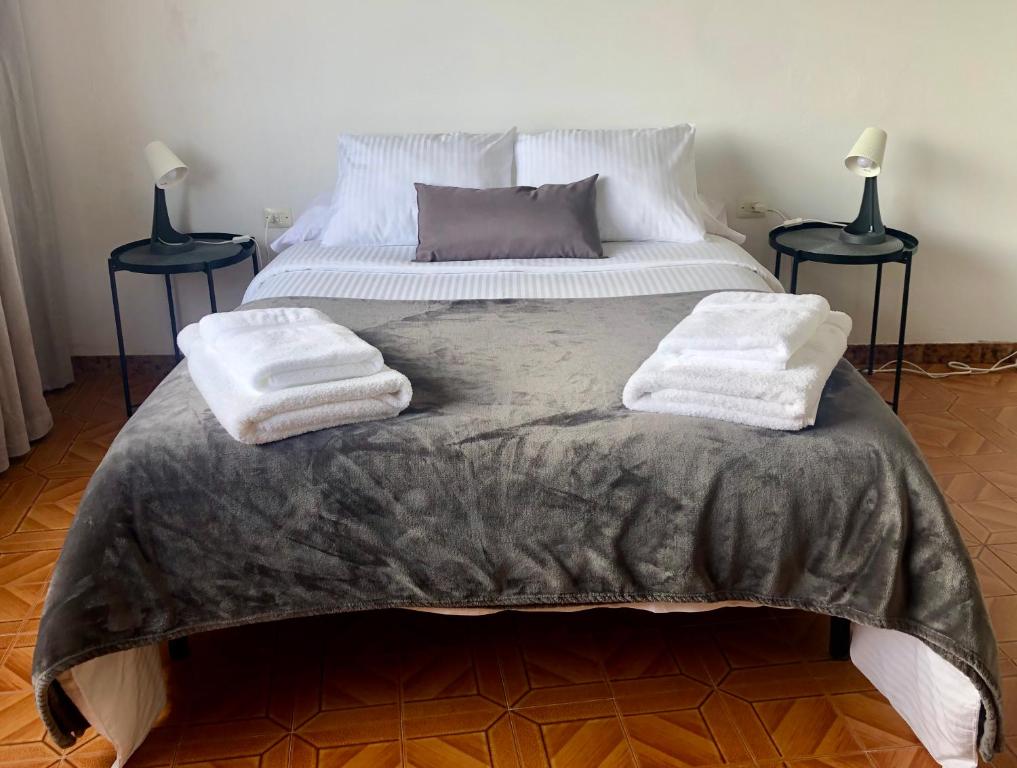 1 dormitorio con 1 cama con 2 toallas en Vivienda de Uso Turístico Cariño en Cariño