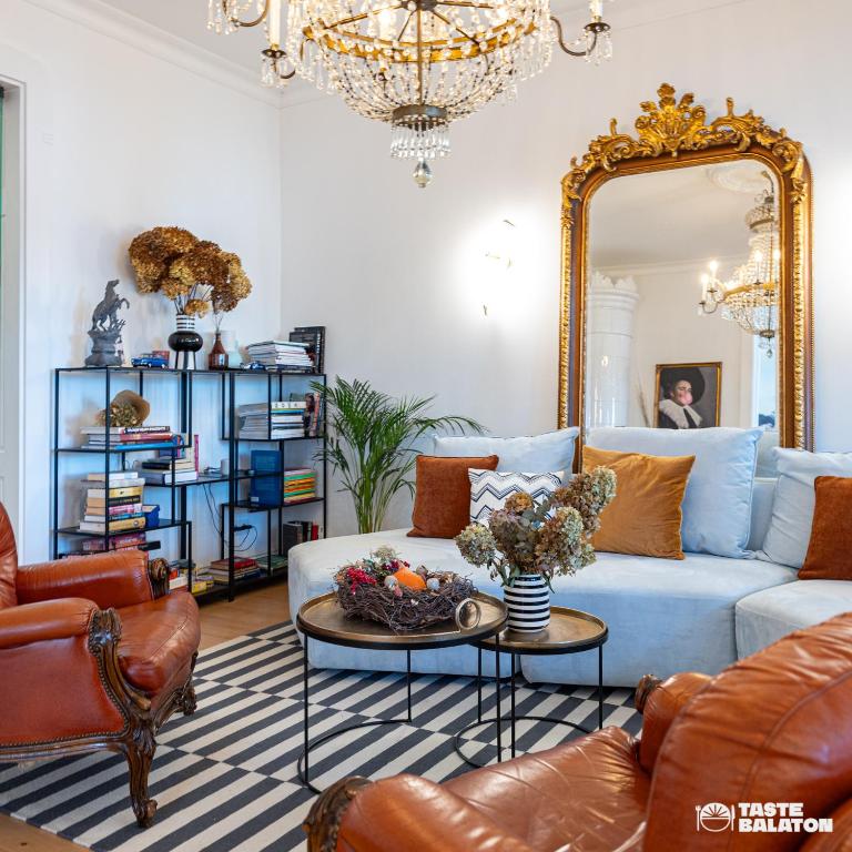 salon z niebieską kanapą i lustrem w obiekcie Villa Chez les Amis - Adults only w mieście Balatonszepezd