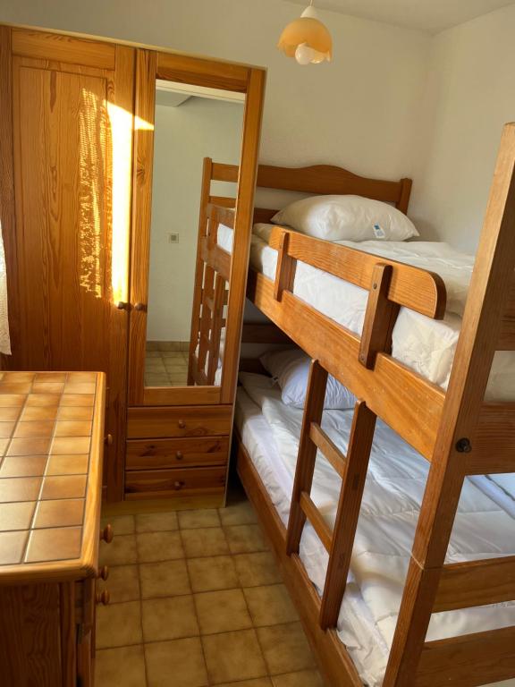 a bedroom with two bunk beds and a mirror at Saint clair in Le Lavandou