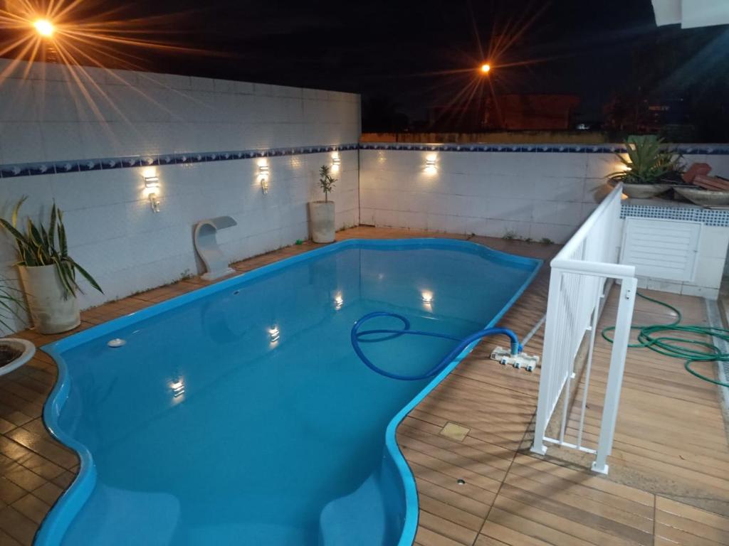 ein Schwimmbad in der Nacht mit Lichtern um ihn herum in der Unterkunft Residence Alto Padrão in Itaboraí