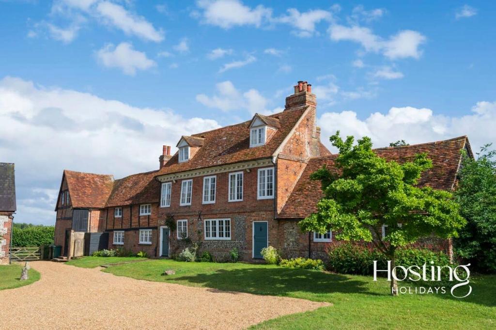 an old brick house with a tree in front of it at Bullocks Farm House - 6 Exceptional Bedrooms in High Wycombe