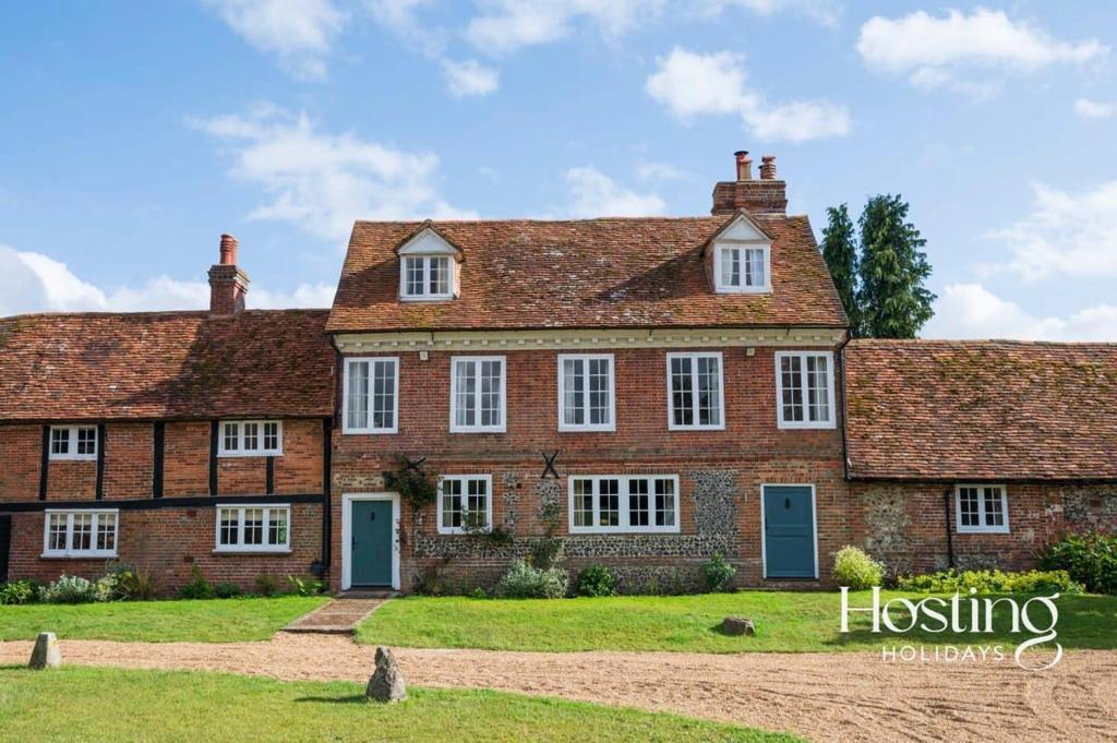 an old brick house with white windows and blue doors at Bullocks Farm House - 6 Exceptional Bedrooms in High Wycombe