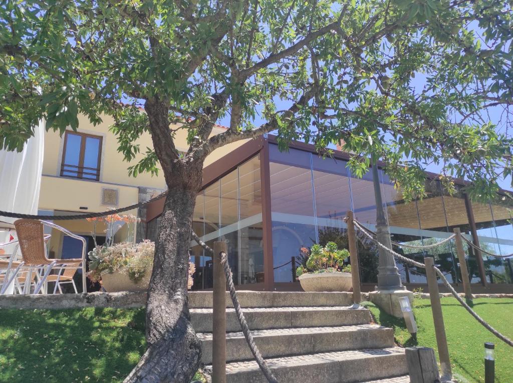 a building with stairs and a tree in front of it at Hotel Rural Sra De Pereiras in Vimioso