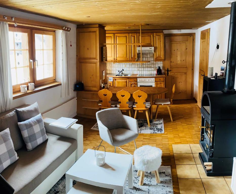a living room with a table and a kitchen at Mountain Getaway Sedrun in Rueras