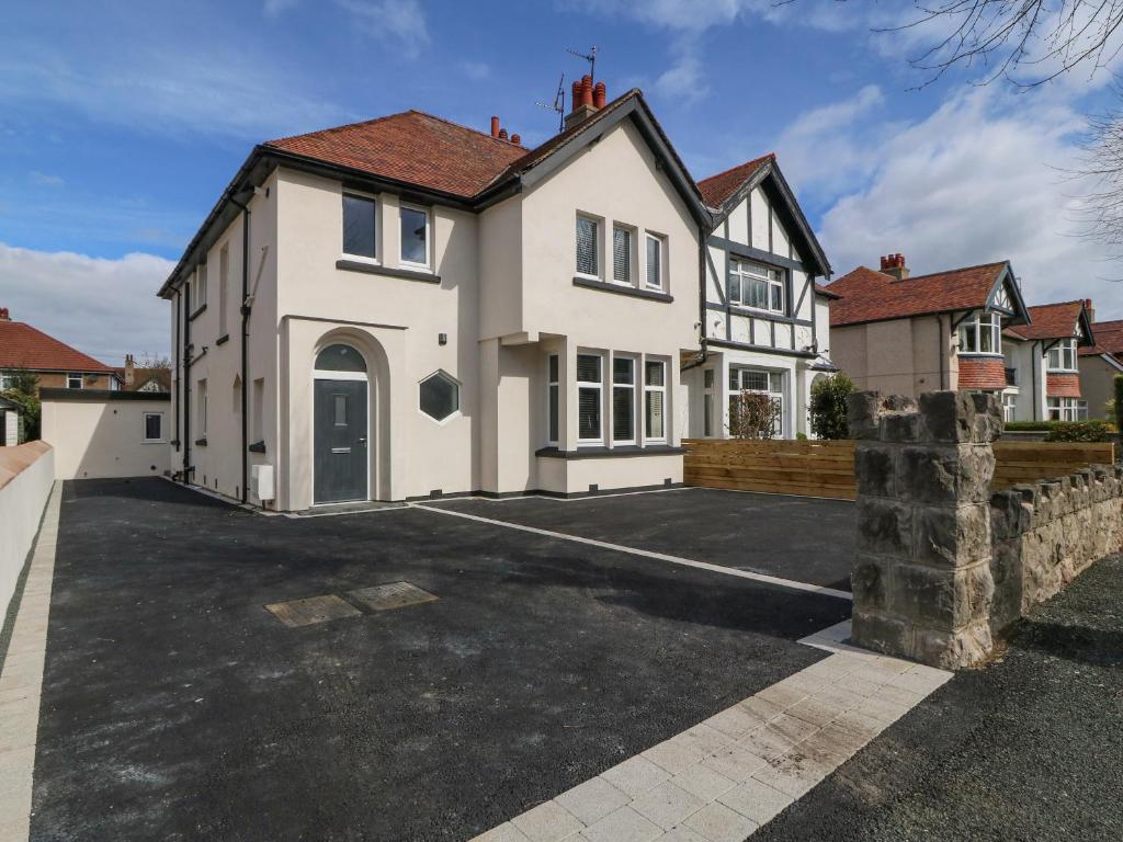 a large white house with a parking lot at Park View in Llandudno