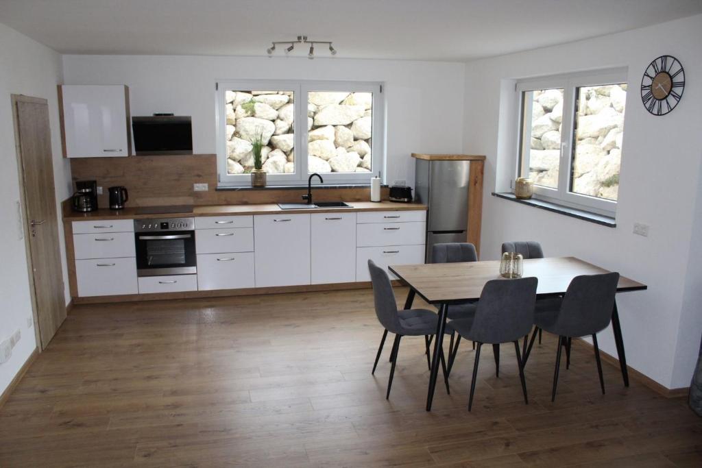 a kitchen with a table and chairs in a room at Ferienwohnung Alpenblick in Wessobrunn
