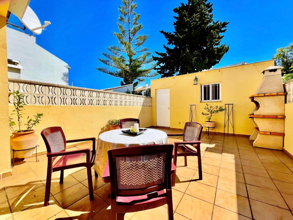 a patio with a table and chairs and a fence at Casa Boga - Urbasur in Islantilla