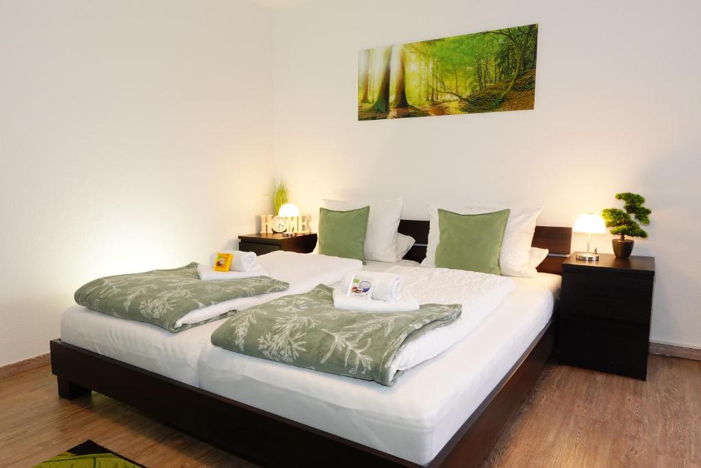 a bedroom with two beds with green pillows at RELAX - GREEN mit Pool und Sauna in Scheidegg