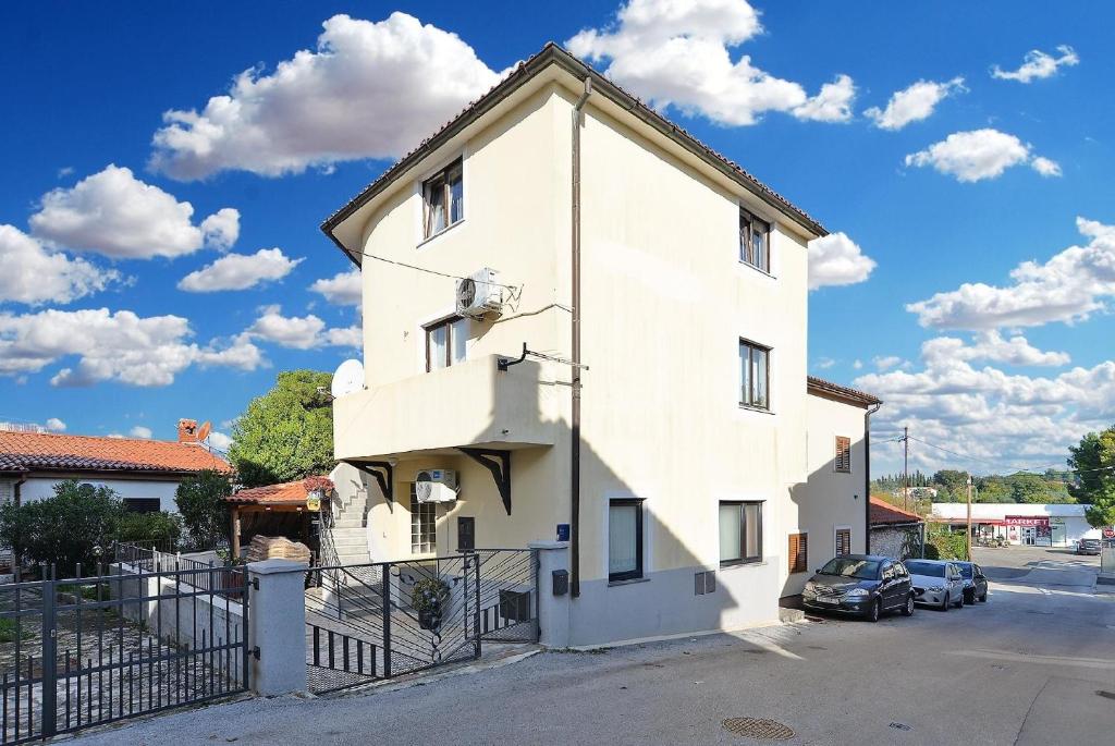 un bâtiment blanc dans une rue avec des voitures garées dans l'établissement Ferienwohnung für 6 Personen ca 45 qm in Pomer, Istrien Istrische Riviera, à Pomer