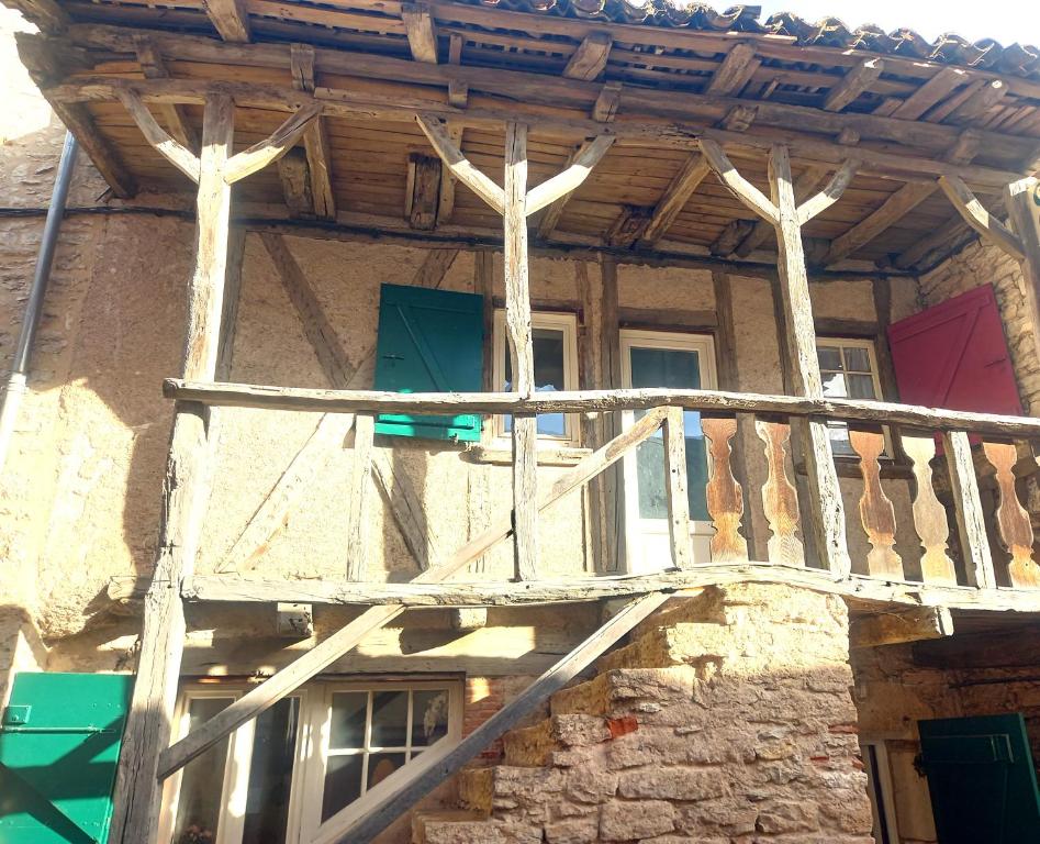un balcón de madera en el lateral de un edificio en Maison médiévale avec jardin dans charmant village, en Vers