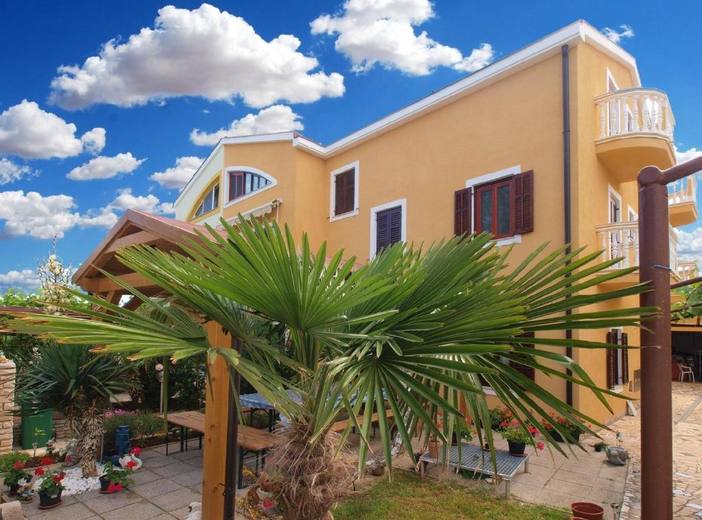 una casa amarilla con una palmera delante de ella en Ferienwohnung für 4 Personen ca 50 qm in Pula-Fondole, Istrien Istrische Riviera - b60852, en Štinjan