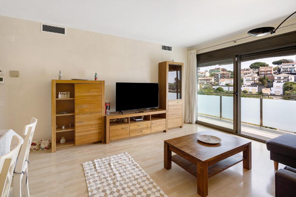 ein Wohnzimmer mit einem großen Fenster und einem TV in der Unterkunft Modern and renewed Apartament Florí in Arenys de Mar