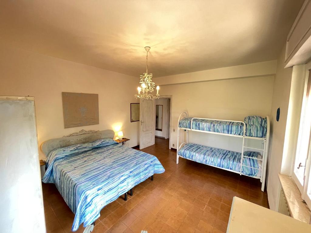 1 dormitorio con 2 camas y lámpara de araña en Sunny Room in a cozy Villa, en Sperlonga