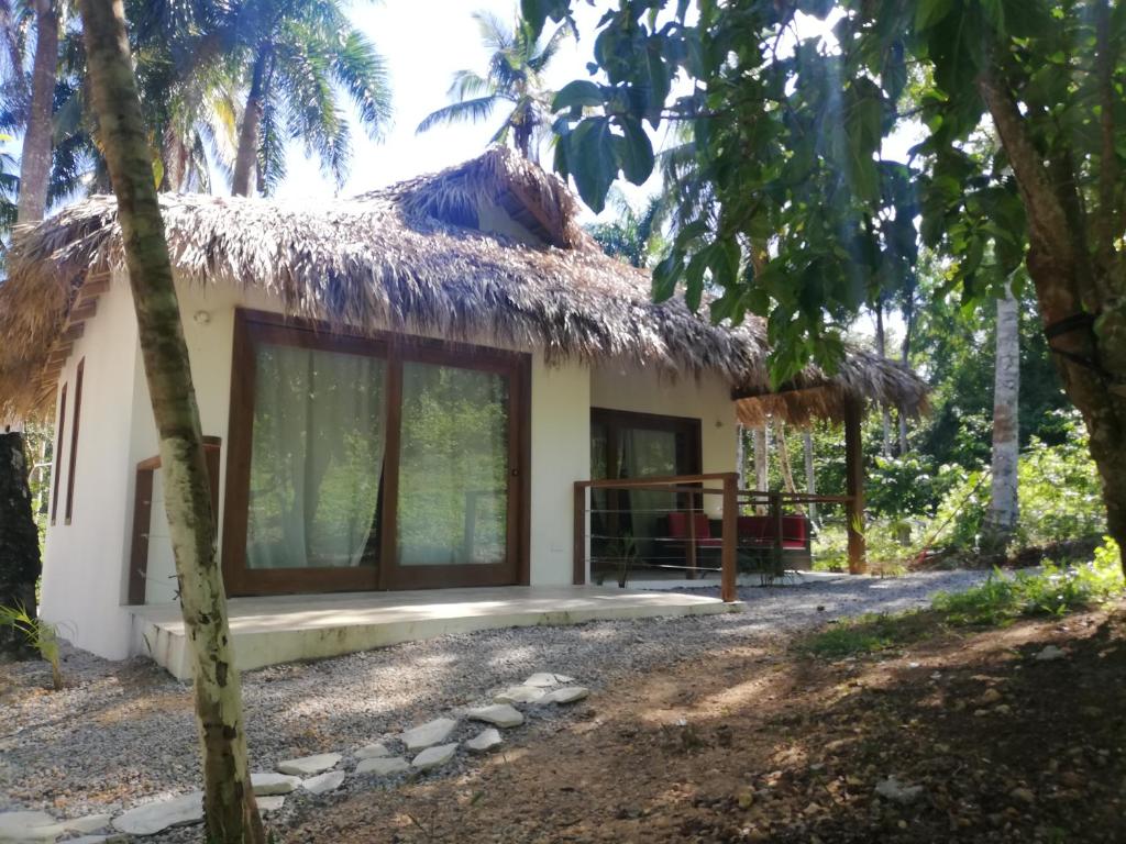 a small house with a thatched roof at Bungalow nel verde in El Limón