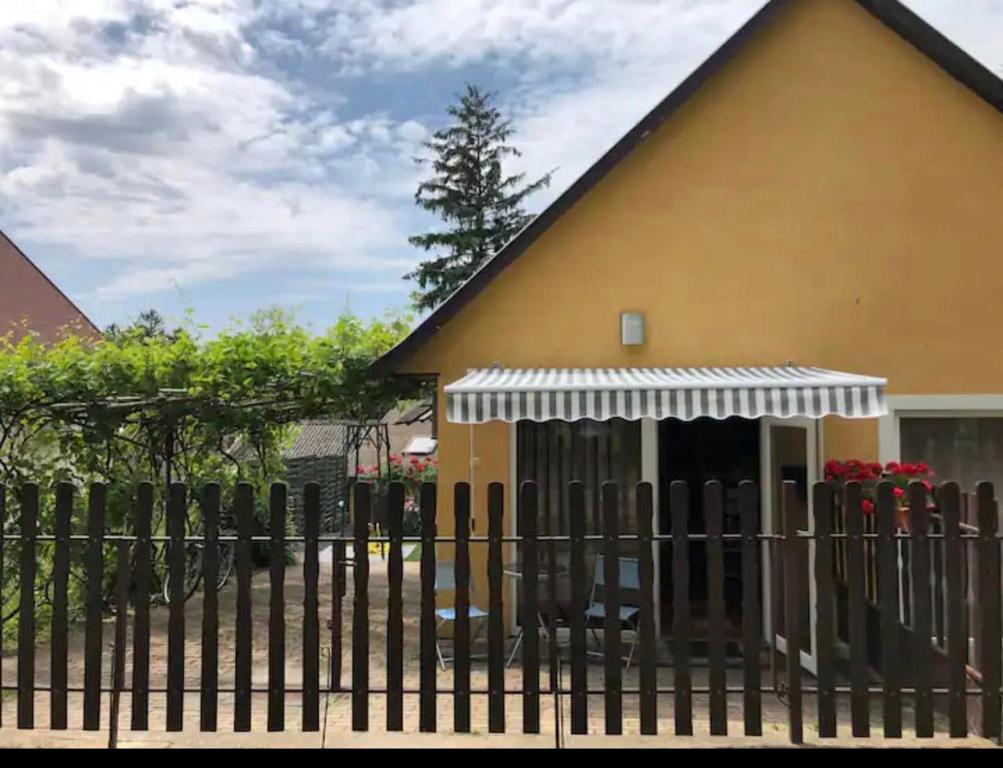 une clôture devant une maison avec un bâtiment dans l'établissement Viola Kisház, à Siófok