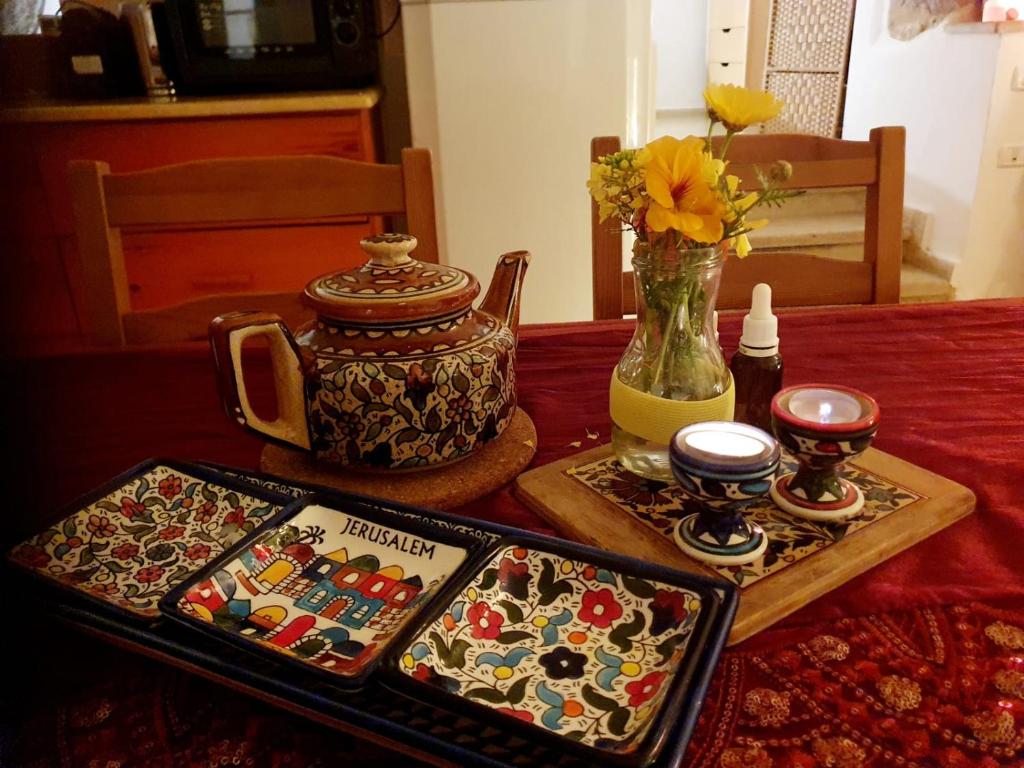 einen Tisch mit einem Tablett mit Essen und einer Vase in der Unterkunft נווה מדבר in Jerusalem