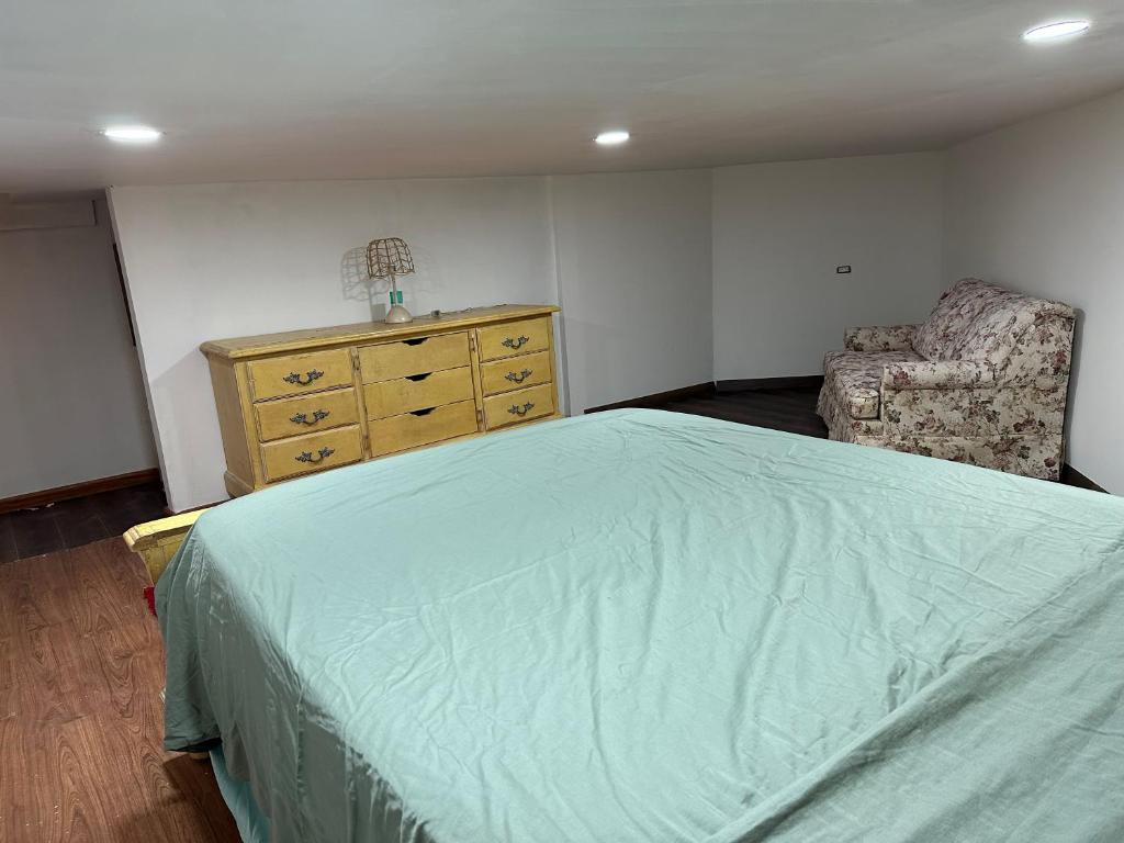 a bedroom with a bed and a dresser and a chair at Habitación para bajitos in San Luis Río Colorado