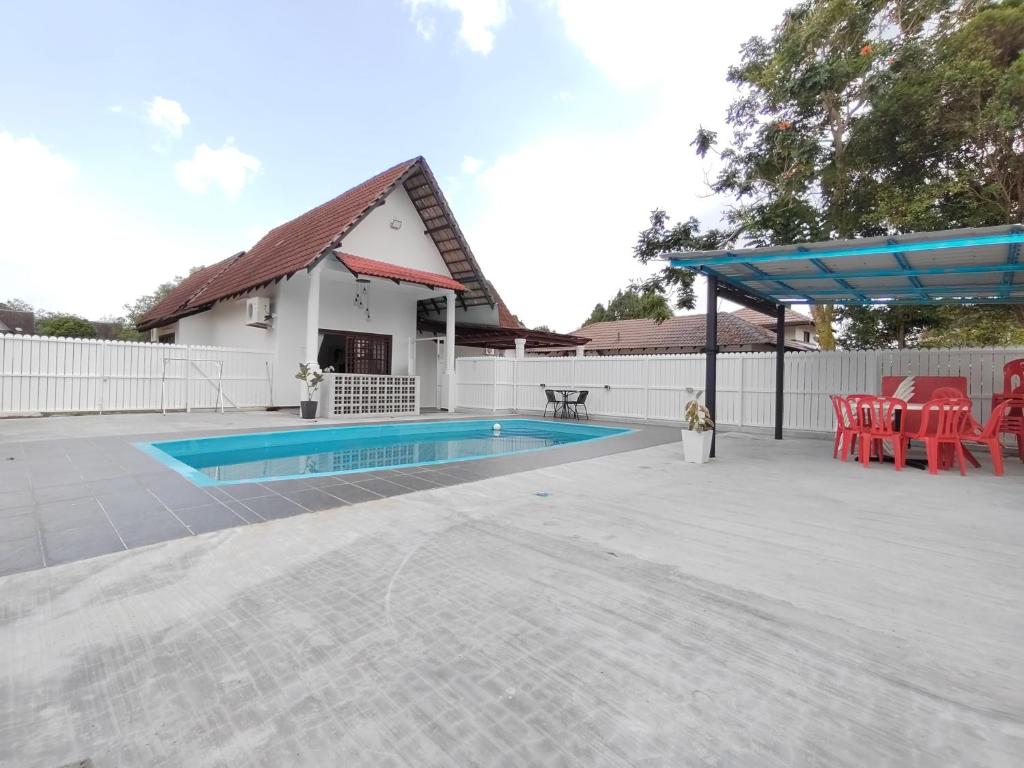 eine Terrasse mit einem Pool, einem Tisch und Stühlen in der Unterkunft Afamosa Chill With US / Private pool / Pool Table in Seremban